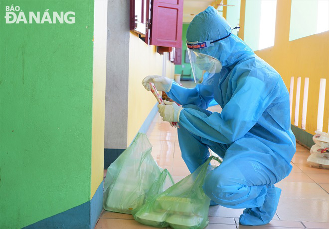 Huy placing meals in front of a quarantined room