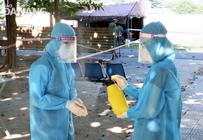 After completing a certain task, Huy (right) and Oanh (left) supporting each other to disinfect themselves