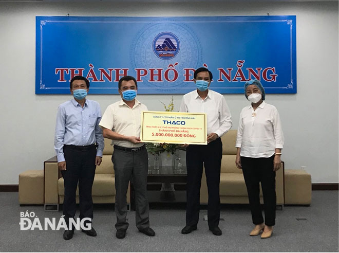 Đại diện THACO trao biển tượng trưng trị giá 5 tỷ cho Phó Chủ tịch UBND thành phố Trần Văn Miên. Ảnh: THÀNH LÂN