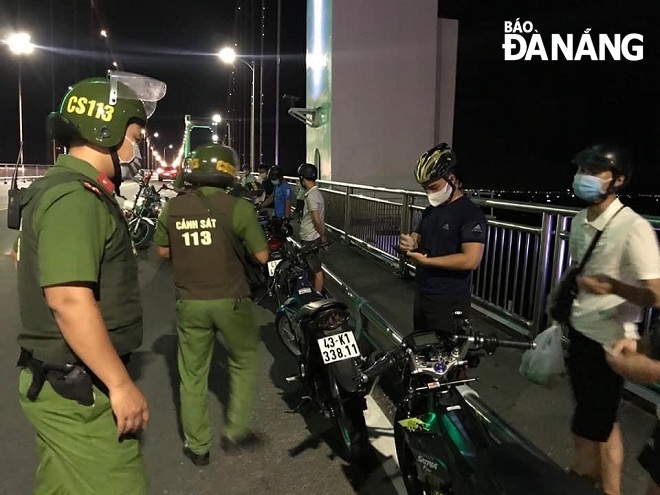 Lực lượng Cảnh sát phản ứng nhanh làm việc với nhóm thanh niên tụ tập trên cầu Thuận Phước tối 10-8. Ảnh: P.C
