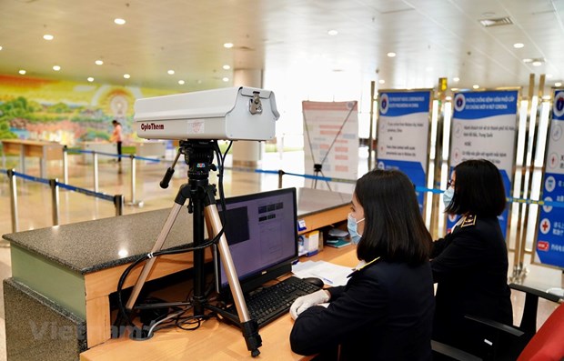 Medical workers in charge of checking passengers' body temperature at Noi Bai International Airport (Photo: VNA)