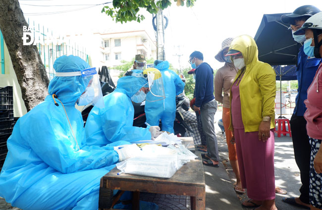 Local medical workers are seen taking samples for novel coronavirus testing from traders in the Son Tra District-basedNai Hien Dong Market