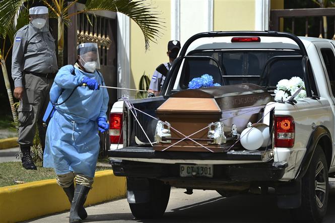  Phun thuốc khử trùng quan tài một y tá tử vong do COVID-19 tại Tegucigalpa, Honduras, ngày 6/8/2020. Ảnh: AFP/ TTXVN