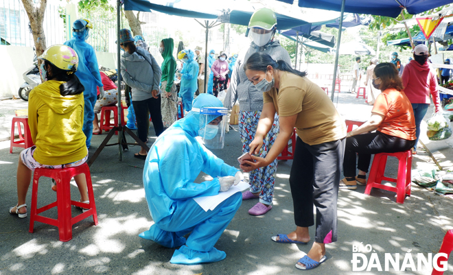 The taking of swab samples from traders and shoppers at the Nai Hien Dong Market in Son Tra District