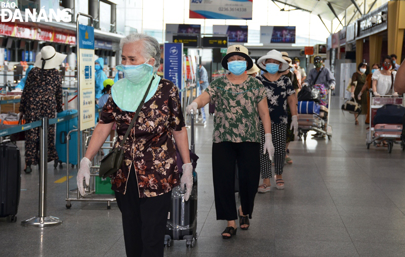 People lining up two meter apart to wait for their turn to perform their check-in procedures at Da Nang International Airport