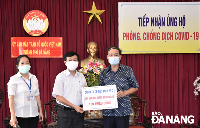 Phó Chủ tịch Ủy ban MTTQ Việt Nam thành phố Dương Đình Liễu (phải) tiếp nhận ủng hộ từ Công ty CP Dệt may 29-3. Ảnh: L.P	