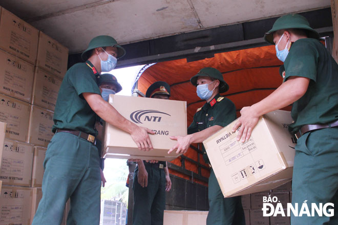 Military officers and men from the 683 Brigade unloading carton boxes of goods at the Kim Lien cargo railway station