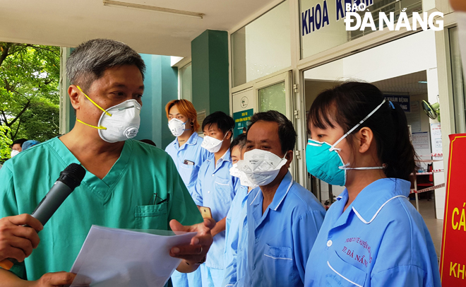 Deputy Minister of Health Nguyen Truong Son handing hospital discharge papers to the fully recovered people who were discharged from the Hoa Vang field hospital