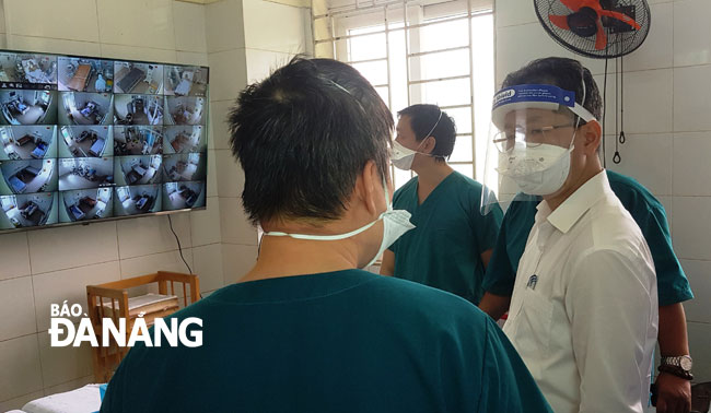 Phó Bí thư Thường trực Nguyễn Văn Quảng (phải) trực tiếp thăm việc điều trị cho các bệnh nhân nặng nhiễm Covid-19 tại Bệnh viện Phổi Đà Nẵng sáng 14-8. Ảnh: PHAN CHUNG