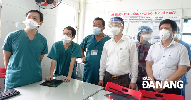 Lãnh đạo Thành ủy cùng các nhân viên y tế tại Bệnh viện Phổi Đà Nẵng theo dõi tình hình bệnh nhân qua hệ thống camera. Ảnh: PHAN CHUNG