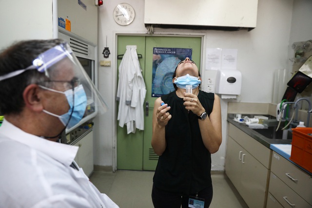 Một phụ nữ súc miệng với nước muối để lấy mẫu xét nghiệm Covid-19 theo phương pháp mới tại Israel. (Ảnh: Retuers)