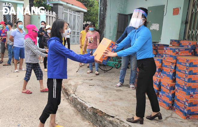 Representatives from the Labour Union in Cam Le District giving boxes of instant noodles to poor and low-income earners in the locality to help them get through the pandemic  
