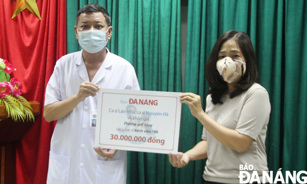 Deputy Editor-in-Chief Tran Thi Thu Thuy (right) handing the donations to a representative from the 199 Hospital