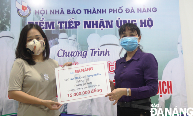 Deputy Editor-in-Chief Tran Thi Thu Thuy (left) handing the donations to a representative from the Da Nang Journalists' Association