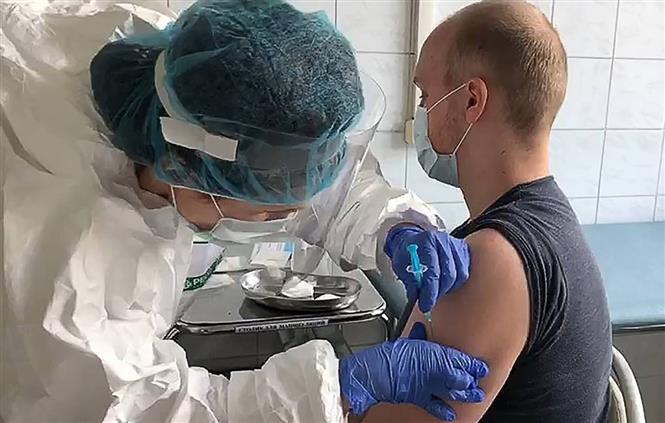 Nhân viên y tế tiêm vaccine ngừa COVID-19 cho tình nguyện viên tại Nga. Ảnh: TASS/ TTXVN