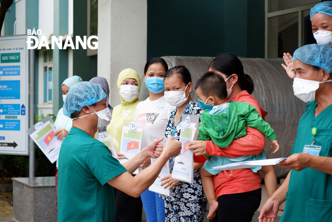 Director of the Hoa Vang District-based Medical Station Nguyen Dai Vinh and some fully-recovered patients