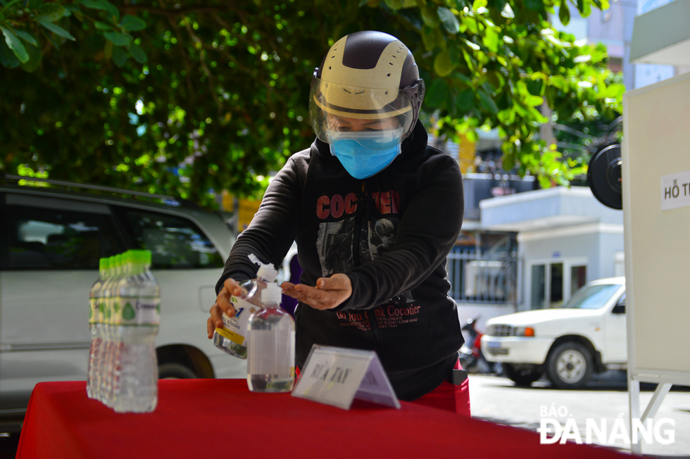 Residents are required to wear face coverings and clean their hands with sanitizer gel before receiving their rice