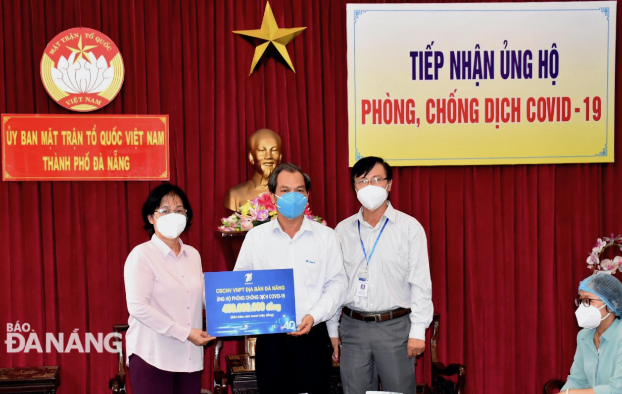 Chairman of the Trade Union of the VNPT Da Nang Nguyen Lam (centre) handing the donations of 450 million VND to a representative from the Da Nang Fatherland Front Committee