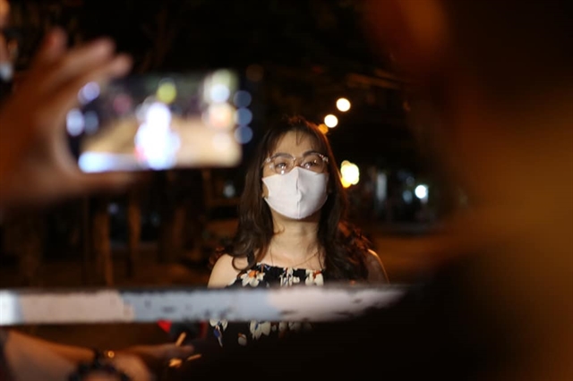 A woman waits for barriers to be lifted at a locked down area in Đà Nẵng. Three hospitals and many living quarters were isolated to prevent COVID-19. VNS Photo Lê Lâm