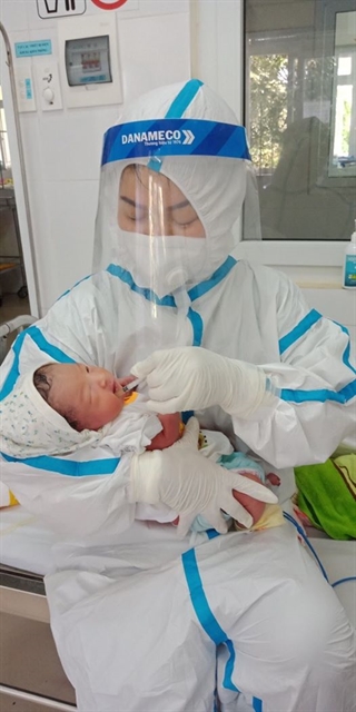 A newborn baby is cared for by a nurse at a quarantine centre in Đà Nẵng. A pregnant COVID-19 patient gave a birth at the centre during treatment. The mother and the new baby were healthy. Photo courtesy of Đà Nẵng health department 