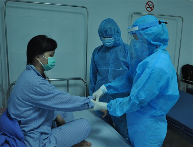 Doctors visit a COVID-19 patient at a hospital in Đà Nẵng. All the best photos and paintings on COVID-19 activities will be displayed at an online exhibition. Photo courtesy of Đà Nẵng health department 