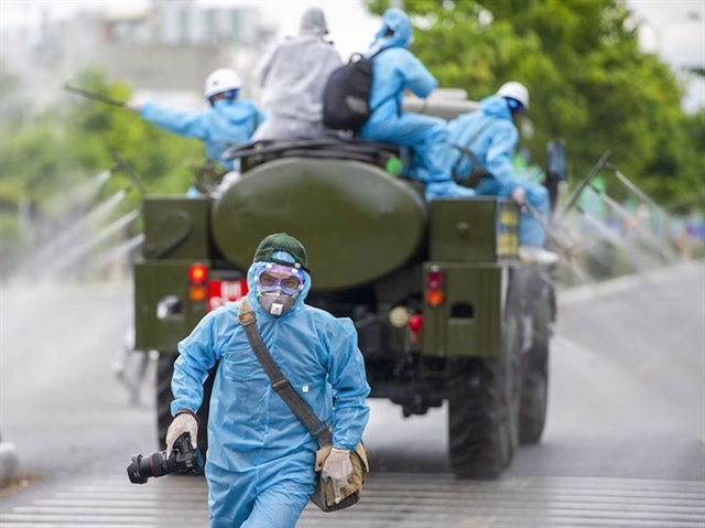 A local photographer after taking a shot of chemical spraying at the COVID-19 hotspot in Đà Nẵng. VNS Photo Nguyễn Đông 