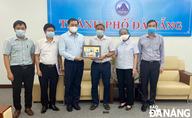 Chủ tịch UBND thành phố Huỳnh Đức Thơ (thứ 3, từ trái) trao quà lưu niệm cho đoàn công tác Bộ Y tế.                                 Ảnh: N.P