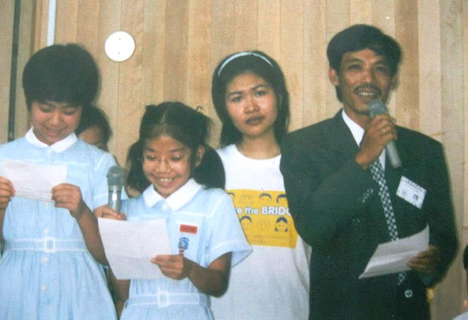 Nhạc sĩ Trương Duy Huyến cùng nữ phiên dịch hướng dẫn trẻ em Nhật Bản và Việt Nam chơi trò chơi trong chuyến đi tham dự trại hè châu Á - Thái Bình Dương tại thành phố Fukuoka (Nhật Bản) năm 1999. (Ảnh do gia đình cung cấp)