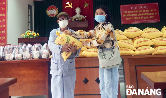 A representative from a city-based business (right) presenting a gift to a poor person in Cam Le District’s Hoa An Ward