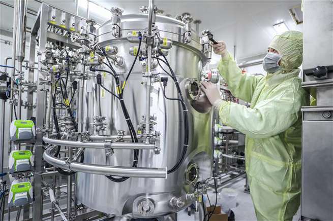  Nhân viên Tập đoàn dược quốc gia Trung Quốc (Sinopharm) điều chỉnh thiết bị sản xuất vaccine tại nhà máy của Tập đoàn ở Bắc Kinh ngày 10-4-2020. Ảnh: THX/TTXVN