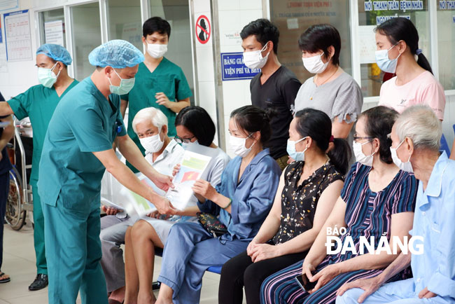 A leader of the Hoa Vang Field Hospital handing hospital discharge papers to people recovered from coronavirus before leaving the hospital on Saturday afternoon