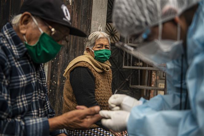 Nhân viên y tế lấy mẫu xét nghiệm COVID-19 cho người dân tại quận Santa Anita, Lima, Peru ngày 20/8/2020. Ảnh: AFP/TTXVN