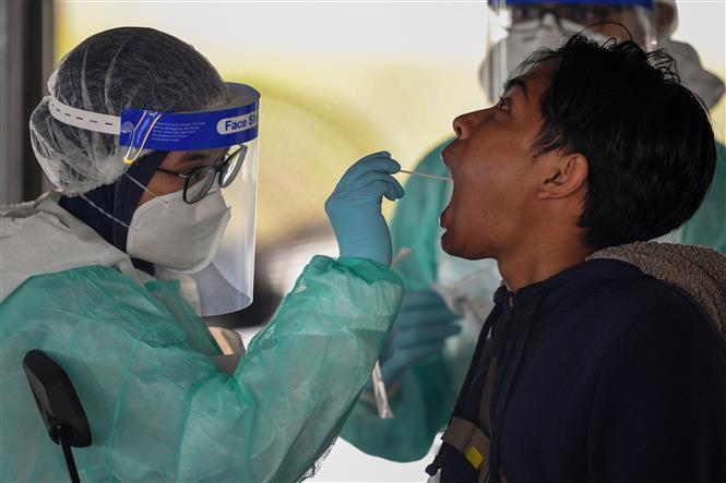 Nhân viên y tế lấy mẫu xét nghiệm COVID-19 cho người dân tại Kuala Lumpur, Malaysia. Ảnh: AFP/TTXVN