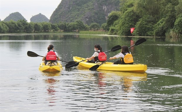 Tourists explore Trang An Scenic Landscape Complex by rowing kayaks (Photo: VNA)