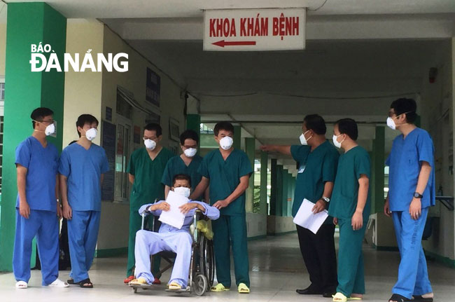 Medical staff of the Lung Hospital helping the critically ill coronavirus patient to complete his hospital discharge procedures