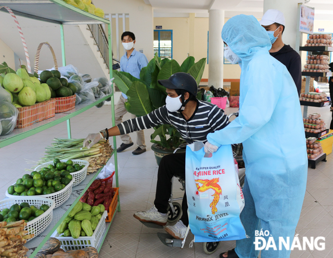 A disabled man doing shopping under the help of a supermarket volunteer 