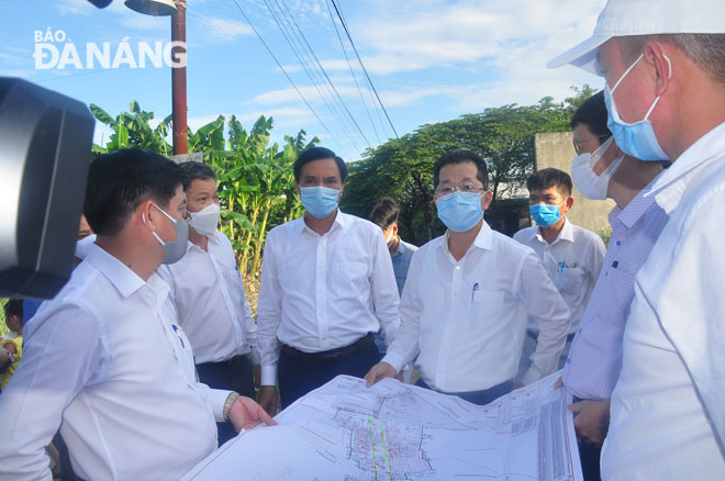 Phó Bí thư Thường trực Nguyễn Văn Quảng (người thứ 4 từ trái sang) nghe báo cáo tình hình triển khai dự án tuyến cống thoát nước Khe Cạn. Ảnh: THÀNH LÂN