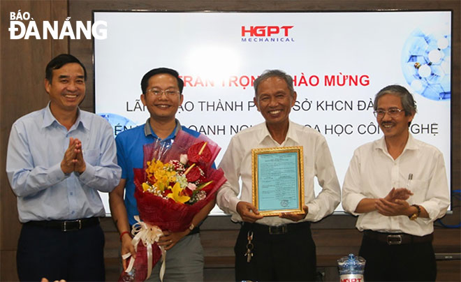 Phó Chủ tịch UBND thành phố Lê Trung Chinh (bìa trái) cùng lãnh đạo Sở Khoa học và Công nghệ (bìa phải) trao giấy chứng nhận doanh nghiệp khoa học và công nghệ cho Công ty CP Cơ khí Hà Giang Phước Tường tháng 11-2019. Ảnh: XUÂN BÌNH