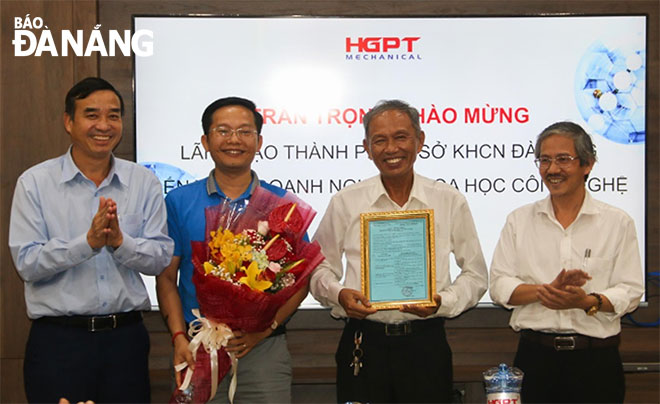 Municipal People's Committee Chairman Le Trung Chinh (1st from left) and a representative of the city’s Department of Science and Technology (1st from right) granting the Certificate of S&T Enterprise for the Ha Giang Phuoc Tuong Mechanical Engineering JSC in November 2019