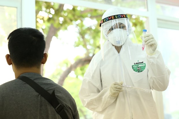 Health woker collects specimens from a person returning from Da Nang city to test for COVID-19 infections (Photo: VNA)