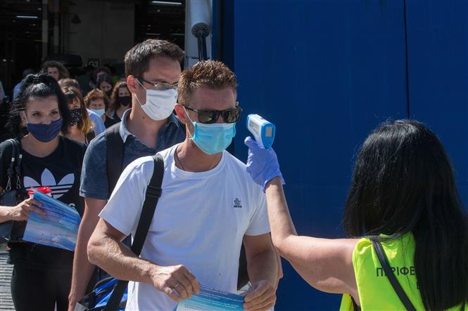 Kiểm tra thân nhiệt cho khách du lịch nhằm ngăn chặn sự lây lan của dịch Covid-19 tại Piraeus, Hy Lạp ngày 20-8-2020. Ảnh: THX-TTXVN