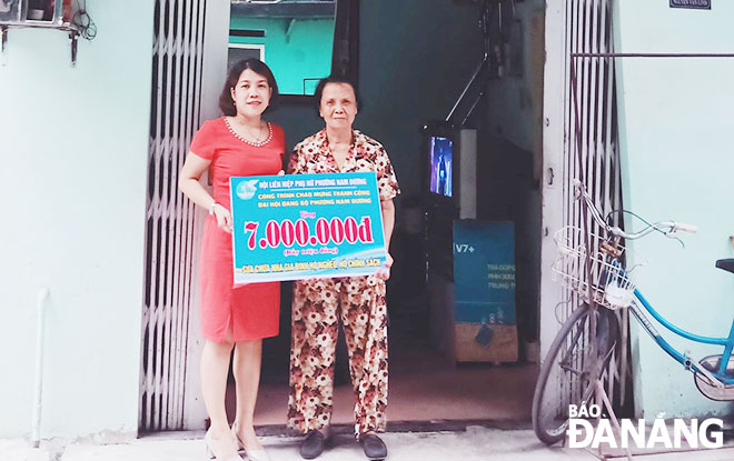 Đại diện Hội Liên hiệp Phụ nữ phường Nam Dương (trái) trao số tiền hỗ trợ 7 triệu đồng cho gia đình bà Phan Thị Hòa để sửa chữa lại căn nhà. (Ảnh chụp tháng 5-2020)Ảnh: QUỐC BẢO	