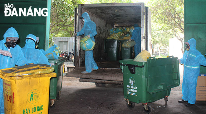 Các công nhân môi trường phân loại, thu gom, xử lý rác thải y tế và chất thải có nguy cơ lây nhiễm dịch bệnh trên địa bàn quận Liên Chiểu. Ảnh: HOÀNG HIỆP