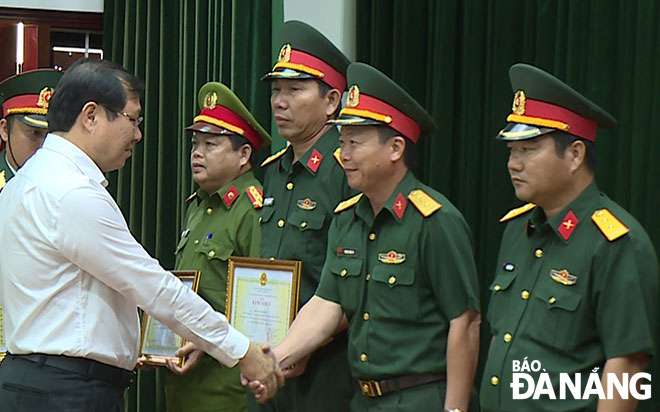 Chủ tịch UBND thành phố Huỳnh Đức Thơ trao bằng khen của Chính phủ cho đơn vị hoàn thành xuất sắc nhiệm vụ diễn tập khu vực phòng thủ năm 2019.Ảnh: HỒNG HẠNH	
