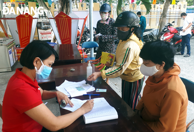 Người dân phường Hòa Khê (quận Thanh Khê) nhận tiền hỗ trợ từ gói 62.000 tỷ đồng của Chính phủ. Ảnh: THANH VÂN