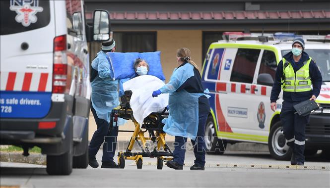 Nhân viên y tế chuyển bệnh nhân mắc Covid-19 lên xe cứu thương tại ngoại ô thành phố Melbourne, bang Victoria, Australia ngày 27-7. Ảnh: AFP-TTXVN