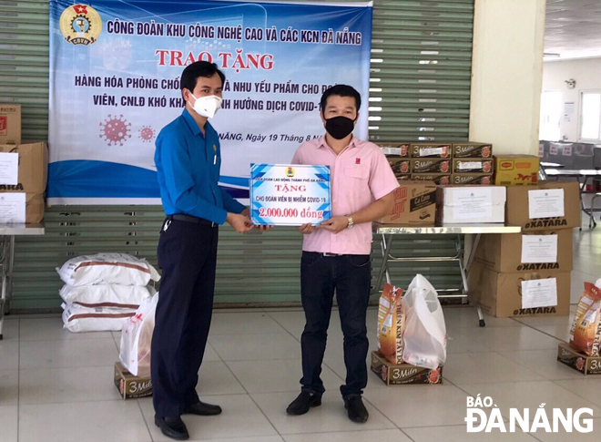 Chủ tịch Liên đoàn Lao động thành phố Nguyễn Duy Minh (trái) thăm, tặng quà cho người lao động sinh hoạt ở Tổ công nhân tự quản khu nhà trọ tại quận Cẩm Lệ.		                Ảnh: NGỌC YẾN