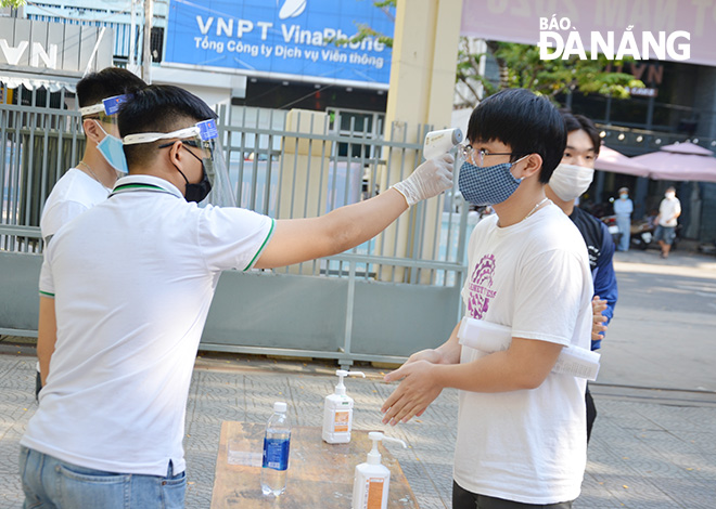 The candidates having their body temperatures measured before entering the exam venues