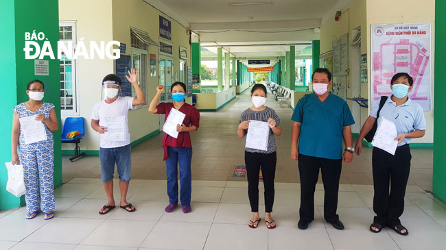 Doctor Le Thanh Phuc, the hospital’s Director handing over hospital discharge papers to the fully-recovered patients on Tuesday morning  