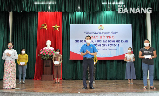 Chairman of the municipal Labour Union Nguyen Duy Minh (centre, in blue) and ...